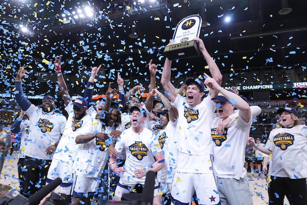 Robert Morris players celebrate with the trophy after defeating Youngstown State in an NCAA college basketball game in the championship of the Horizon League tournament in Indianapolis, Tuesday, March 11, 2025. (AP Photo/Michael Conroy)