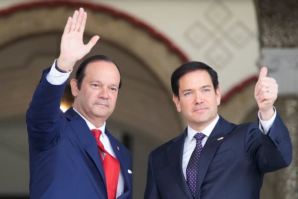 U.S. Secretary of State Marco Rubio, right, waves after being welcomed by Panama's Foreign Minister Javier Martinez-Acha, left, upon his arrival at the presidential palace in Panama City, Sunday, Feb. 2, 2025. (AP Photo/Mark Schiefelbein, Pool)