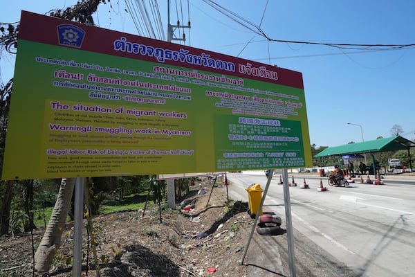 A sign near military checkpoint warns in Thai, English and Chinese of the danger of being trafficked and forced to work in locked scam compounds across the Myanmar border, in Mae Sot, Thailand, Wednesday, Feb. 26, 2025. (AP Photo/Sakchai Lalit)