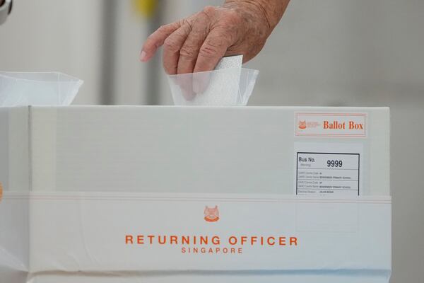 A Singaporean voter casts their vote for general election at polling station in Singapore, Saturday, May 3, 2025. (AP Photo/Vincent Thian)