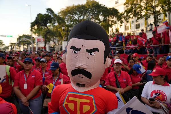 A person dressed as Super Mustache, a character depicting President Nicolas Maduro as a superhero, stands with pro-government supporters at Miraflores Palace, days ahead of Maduro's presidential inauguration for a third term in Caracas, Venezuela, Wednesday, Jan 8, 2025. (AP Photo/Ariana Cubillos)