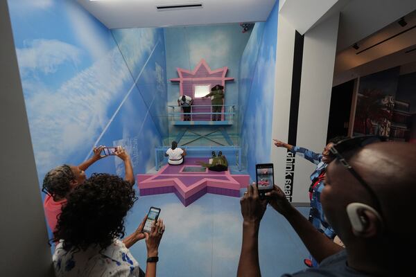 Members of the Miller family from Memphis, Tenn. pose in an installation creating an optical illusion as they visit Paradox Museum Miami during a family trip celebrating the 50th birthday of Cassandra Miller, top right, Tuesday, Jan. 28, 2025, in Miami. (AP Photo/Rebecca Blackwell)