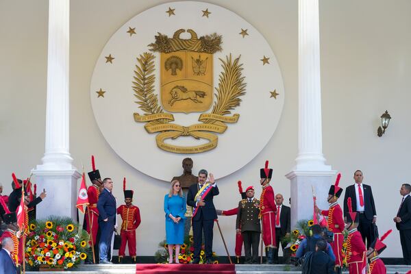 Venezuelan President Nicolas Maduro and his wife Cilia Flores wave after his swearing-in ceremony for a third term at the National Assembly in Caracas, Venezuela, Friday, Jan. 10, 2025. (AP Photo/Ariana Cubillos)