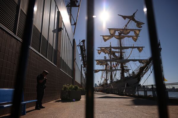 A New York Police officer stands watch on Pier 35 where the Cuauhtémoc, a masted Mexican Navy training ship that collided with the Brooklyn Bridge the night before, sits docked. (AP Photo/Yuki Iwamura)