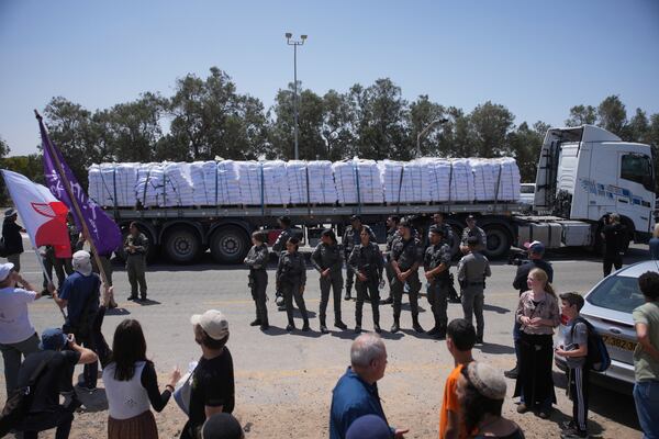 A truck loaded with humanitarian aid for the Gaza Strip makes its way to the Kerem Shalom crossing as border police officers prevent activists from blocking the road in southern Israel, Wednesday, May 21, 2025. (AP Photo/Ohad Zwigenberg)