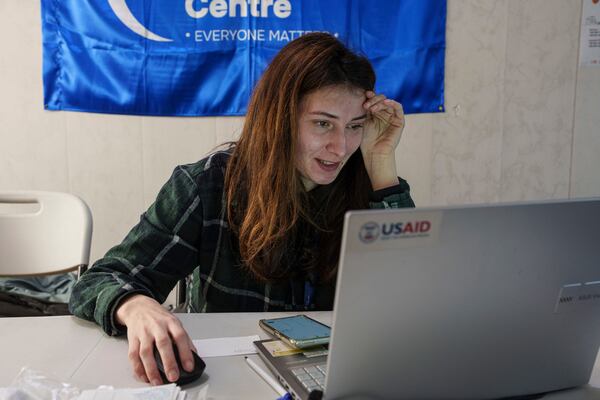 A social worker looks at a laptop with a USAID logo, at a center for displaced people in Pavlohrad, Ukraine, Saturday, Feb. 1, 2024. (AP Photo/Evgeniy Maloletka)