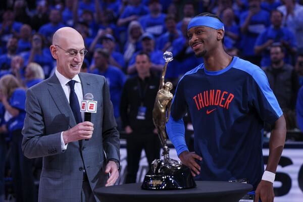 NBA commissioner Adam Silver, left, presents the Michael Jordan Most Valuable Player trophy to Oklahoma City Thunder guard Shai Gilgeous-Alexander prior to Game 2 of an NBA basketball Western Conference Finals playoff series between against the Minnesota Timberwolves Thursday, May 22, 2025, in Oklahoma City. (AP Photo/Nate Billings)