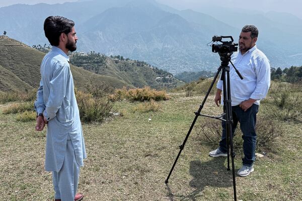 A cameraman records an interview with a villager during a government's organized trip for media to Bella Noor Shah, a mountainous village near Muzaffarabad, the capital of Pakistan administered Kashmir, Monday, May 5, 2025. (AP Photo/Muhammad Yousuf, Pool)
