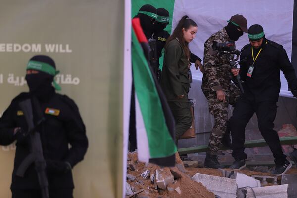 Israeli soldier Agam Beger walks next to masked Islamic Jihad militants as she is handed over to the Red Cross at the Jabalya refugee camp in Gaza City, Thursday Jan. 30, 2025.(AP Photo/Mohammed Hajjar)