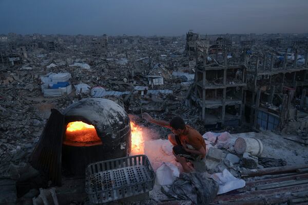 Palestinians Ali Marouf cook on fire on the roof of his destroyed house by the Israeli army's air and ground offensive in Jabaliya, Gaza Strip, on Monday, March 17, 2025. (AP Photo/Jehad Alshrafi)