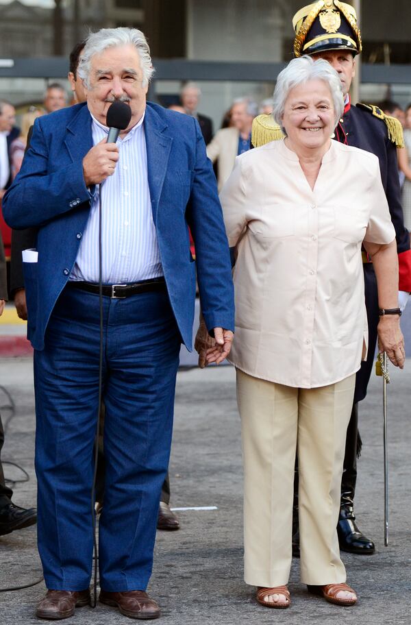 FILE - Uruguay's President Jose Mujica, left, and his wife Lucia Topolansky attend a flag ceremony in Montevideo, Uruguay, Feb. 27, 2015. (AP Photo/Matilde Campodonico, File)