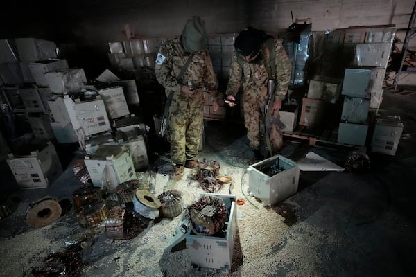 Syrian members of the rebel group inspecting electrical components that were used to hide amphetamine pills known as Captagon hidden at the warehouse where the drug was manufactured before the fall of Bashar Assad government at a facility in Douma city, outskirts of Damascus, Syria, Friday, Dec. 13, 2024. (AP Photo/Hussein Malla)