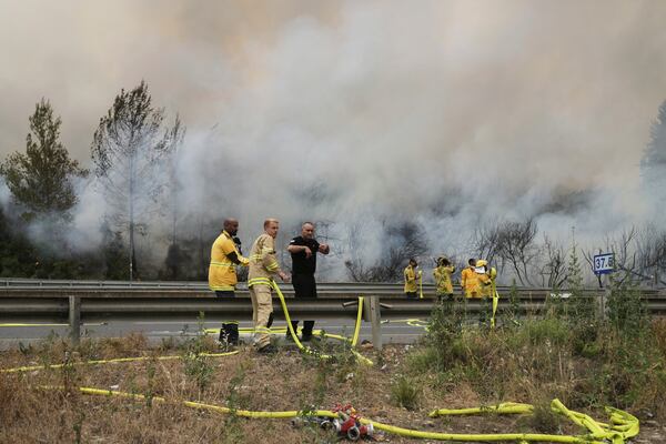Firefighters work to extinguish a forest fire burning on a freeway to Jerusalem, Wednesday, April 30, 2025. (AP Photo/Mahmoud Illean)
