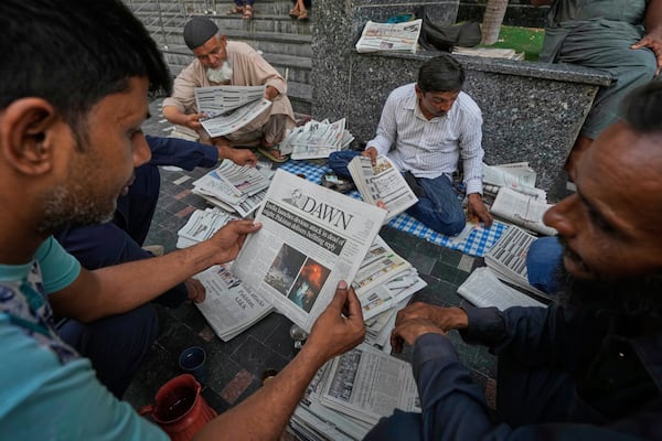 People read morning newspapers leading with the story of India firing missiles into Pakistani territory, in Karachi, Pakistan, Wednesday, May 7, 2025. (AP Photo/Fareed Khan)