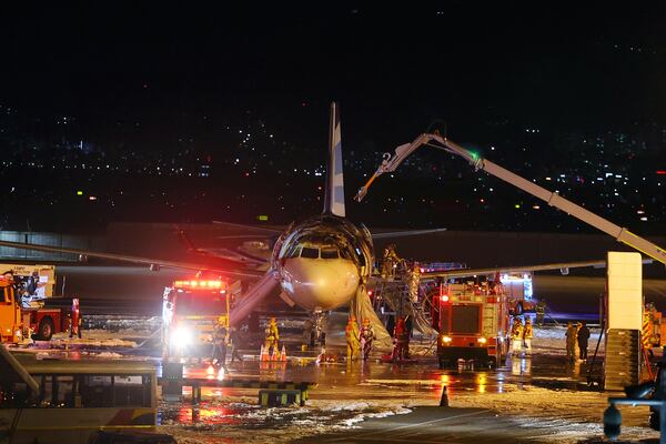 Firefighters work to extinguish a fire on an Air Busan airplane at Gimhae International Airport in Busan, South Korea, Tuesday, Jan. 28, 2025. (Son Hyung-joo/Yonhap via AP)