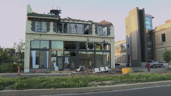 A building is damaged as debris covers the ground after a severe storm passed the area on Saturday, May 17, 2025 in St. Louis, Mo. ( KMOV via AP)