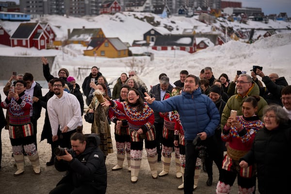 Relatives and family members throw rice at Salik and Malu Schmidt as they leave the church of our Savior after getting married in Nuuk, Greenland, Saturday, Feb. 15, 2025. (AP Photo/Emilio Morenatti)