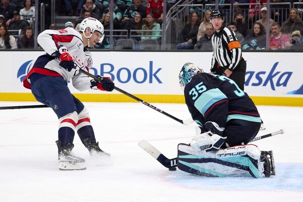 Seattle Kraken goaltender Joey Daccord (35) blocks a shot by Washington Capitals center Lars Eller (20) during the third period of an NHL hockey game, Thursday, Jan. 23, 2025, in Seattle. (AP Photo/John Froschauer)