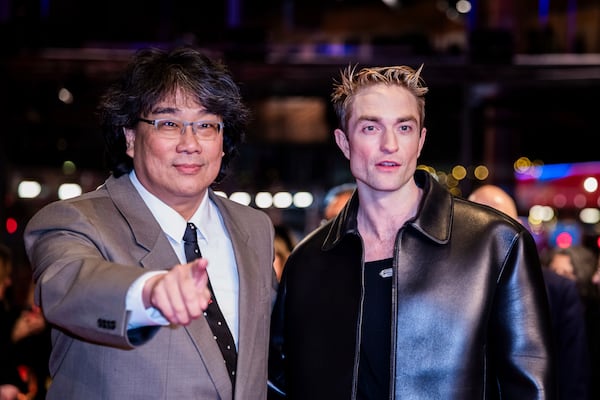 Actor Robert Pattinson, right, and Bong Joon-ho, left, pose for the photographers as they arrive for the screening of the film 'Mickey 17' at the International Film Festival, Berlinale, in Berlin, Saturday, Feb. 15, 2025. (Christoph Soeder/dpa via AP)