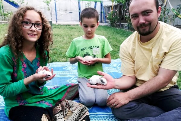 This family photo shows Ryan Corbett holding rabbits with his daughter Miriam and son Caleb in Kabul, Afghanistan in 2020. (AP Photo/Anna Corbett)