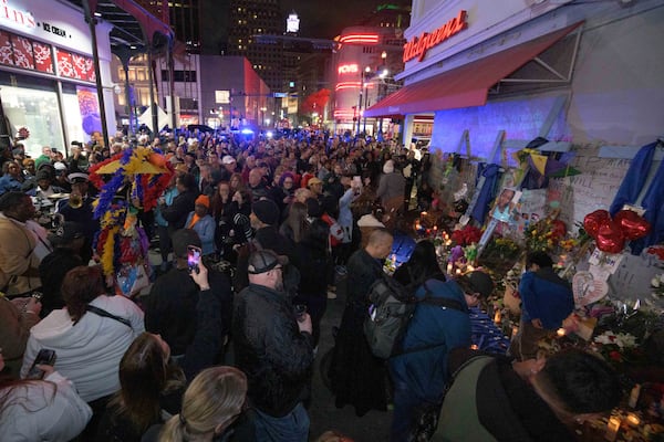 People crowd Bourbon Street near the intersection of Canal Street in New Orleans, Saturday, Jan. 4, 2025, as they memorialize the victims of the New Year's Day deadly truck attack and shooting. (AP Photo/Matthew Hinton)