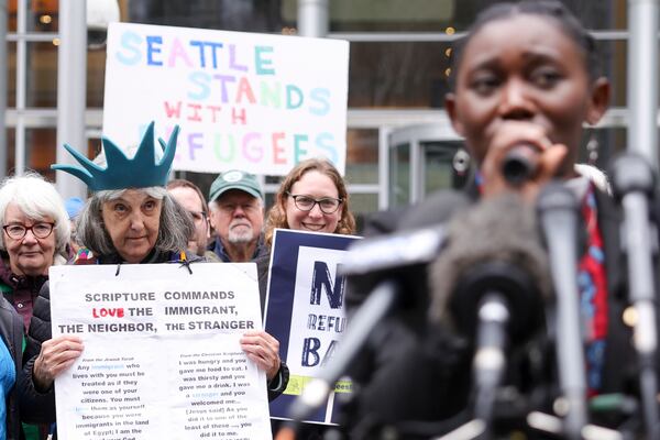 Retired reverend Carrol Jensen wears a hat mimicking the Statue of Liberty as Reverend Emilie Binja, a former refugee from the Democratic Republic of Congo speaks during a rally outside the U.S District Court after a federal judge blocked President Donald Trump's effort to halt the nation's refugee admissions system, Tuesday, Feb. 25, 2025 in Seattle. (AP Photo/Ryan Sun)