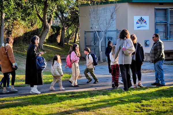 Palisades Charter Elementary School students and their parents arrive at their new school, the Brentwood Elementary Science Magnet school in the Brentwood section of Los Angeles on Wednesday, Jan. 15, 2025. (AP Photo/Richard Vogel)