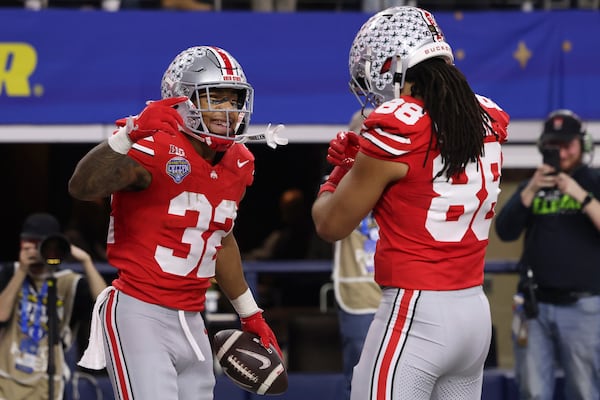 Ohio State running back TreVeyon Henderson (32) is congratulated by tight end Gee Scott Jr. (88) after scoring against Texas during the first half of the Cotton Bowl College Football Playoff semifinal game, Friday, Jan. 10, 2025, in Arlington, Texas. (AP Photo/Gareth Patterson)