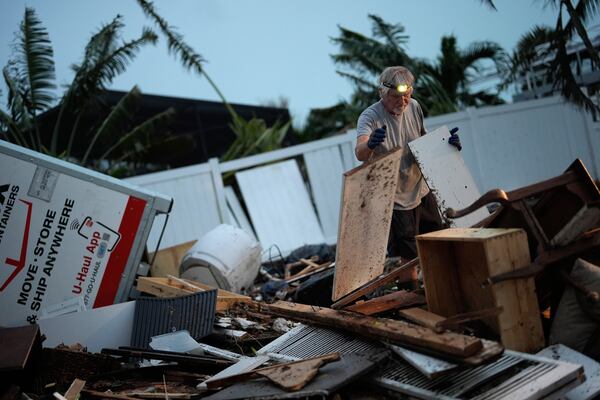 FILE - Robert Turick, 68, works to clear household debris that Hurricane Milton storm surge swept from other properties into his canal-facing back yard, in Englewood, Fla., Friday, Oct. 11, 2024. (AP Photo/Rebecca Blackwell, File)