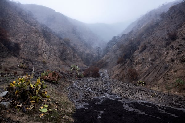 Water streams down a canyon in the Eaton Fire zone during a storm, Thursday, Feb. 13, 2025, in Altadena, Calif. (AP Photo/Etienne Laurent)