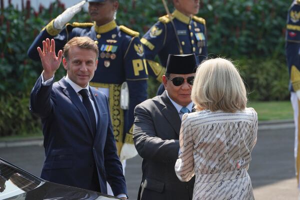 Indonesian President Prabowo Subianto, center, shakes hands with French first lady Brigitte Macron as French President Emmanuel Macron waves before their meeting at Merdeka Palace in Jakarta, Indonesia, Wednesday, May 28, 2025. (AP Photo/Achmad Ibrahim)
