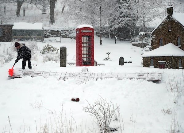 Lowson Robinson is pictured in the heavy snow with his scaled miniature famous landmarks which are located in his garden in Nenthead, England, as the severe weather continues across England, Sunday, Jan. 5, 2025. (AP Photo/Scott Heppell)