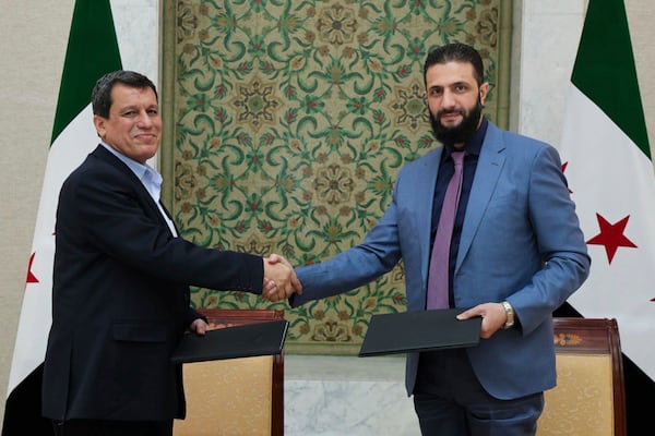 In this photo released by Syrian state news agency SANA, Syria's interim President Ahmad al-Sharaa, right, shakes hands with Mazloum Abdi, the commander of the U.S.-backed Kurdish-led Syrian Democratic Forces, in Damascus, Syria, Monday, March 10, 2025. (SANA via AP)