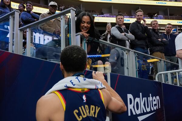 Golden State Warriors guard Stephen Curry, foreground, talks to his wife Ayesha Curry after the team's victory over the Sacramento Kings in an NBA basketball game Thursday, March 13, 2025, in San Francisco. (AP Photo/Godofredo A. Vásquez)