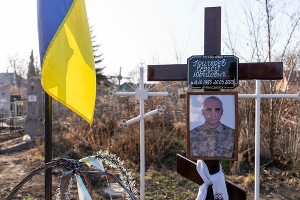 A portrait of Serhii Hryhoriev, a Ukrainian prisoner of war who died in Russia, is seen next to his grave in Pyriatyn, Ukraine, March 9, 2025. (AP Photo/Alex Babenko)