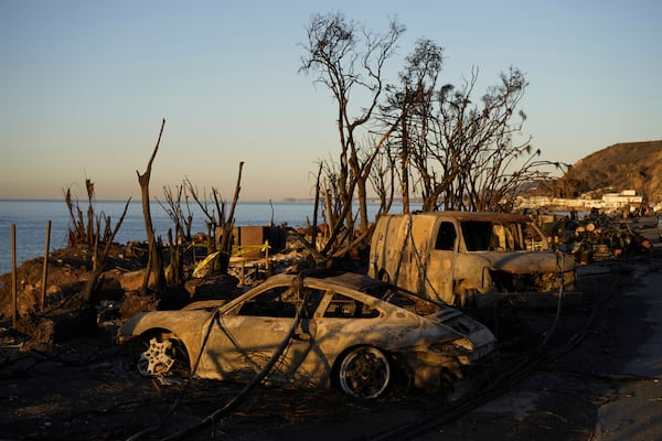 Charred vehicles sit along the Pacific Coast Highway, Tuesday, Jan. 14, 2025, in Malibu, Calif. (AP Photo/Carolyn Kaster)