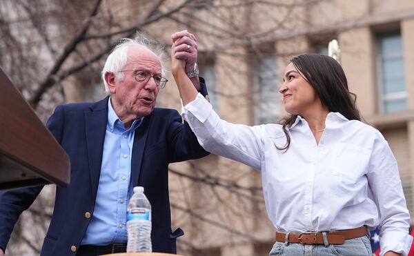FILE _ Sen. Bernie Sanders, I-Vt., left, greets Rep. Alexandria Ocasio-Cortez, D-N.Y., as they speak during a stop of their "Fighting Oligarchy" tour at Civic Center Park, March 21, 2025, in Denver. (AP Photo/David Zalubowski, File)