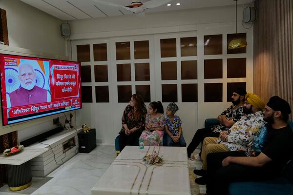 Family members watch the live telecast of Indian Prime Minister Narendra Modi's speech on a television at their residence in Hyderabad, India, Monday, May 12, 2025. (AP Photo/Mahesh Kumar A.)