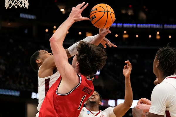 Alabama guard Chris Youngblood, left, knocks the ball away from Saint Mary's center Harry Wessels (1) in front of teammate Mouhamed Dioubate in the second half in the second round of the NCAA college basketball tournament, Sunday, March 23, 2025, in Cleveland. (AP Photo/Sue Ogrocki)