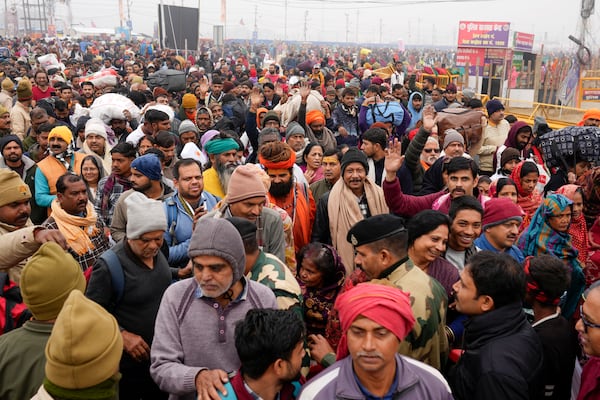 Devotees arrive for taking a dip at the confluence of the Ganges, the Yamuna and the mythical Saraswati rivers on the first day of the 45-day-long Maha Kumbh festival in Prayagraj, India, Monday, Jan. 13, 2025. (AP Photo/Rajesh Kumar Singh)