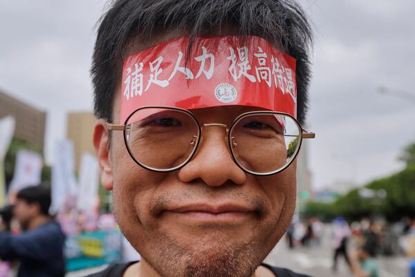 A Taiwanese worker sticks a slogan on the head reading "Supplement manpower and improve treatment." during a May Day rally in Taipei, Taiwan, Thursday, May 1, 2025. (AP Photo/Chiang Ying-ying)
