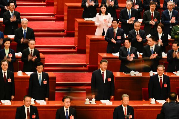 Chinese President Xi Jinping, centre, stands during the opening session of the National People's Congress (NPC) at the Great Hall of the People in Beijing, China, Wednesday, March 5, 2025. (AP Photo/Ng Han Guan)