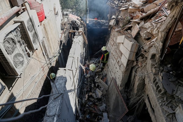 Firemen work at the site of an Israeli missile strike in Damascus, Syria, Thursday March 13, 2025.(AP Photo/Omar Sanadiki)