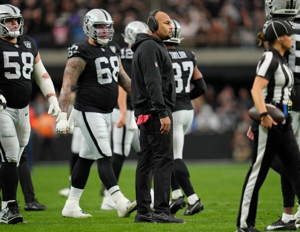 FILE - Las Vegas Raiders head coach Antonio Pierce, center, stands on the field during the first half of an NFL football game against the Los Angeles Chargers, Jan. 5, 2025, in Las Vegas. (AP Photo/Abbie Parr, File)