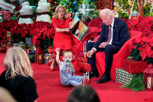 President Joe Biden and first lady Jill Biden, as she reads 'Twas the Night Before Christmas, visit patients and families at the Children's National Hospital in Washington, Friday, Dec. 20, 2024. (AP Photo/Ben Curtis)