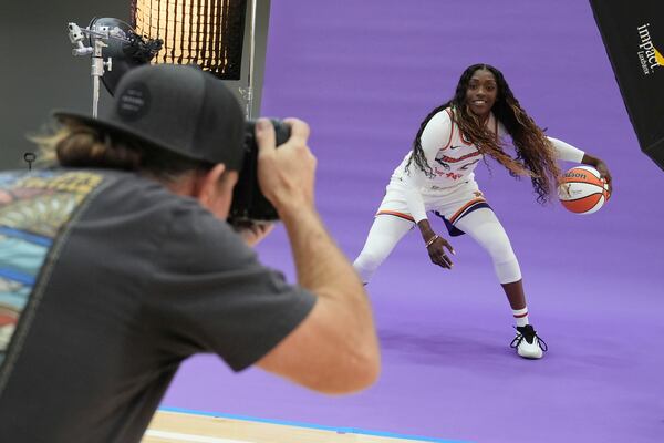 Phoenix Mercury guard-forward Kahleah Copper, right, dribbles the ball in front of team photographer Barry Gossage during a photo shoot at Mercury Media Day at the team's WNBA basketball training facility, Wednesday, April 30, 2025, in Phoenix. (AP Photo/Ross D. Franklin)