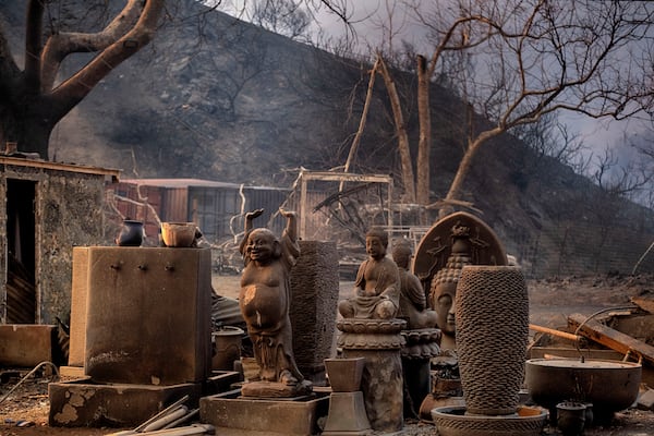 Charred Buddha statues stand amidst other sculptures at burned out shop in Malibu, Calif., Wednesday, Jan. 8, 2025. (AP Photo/Richard Vogel)