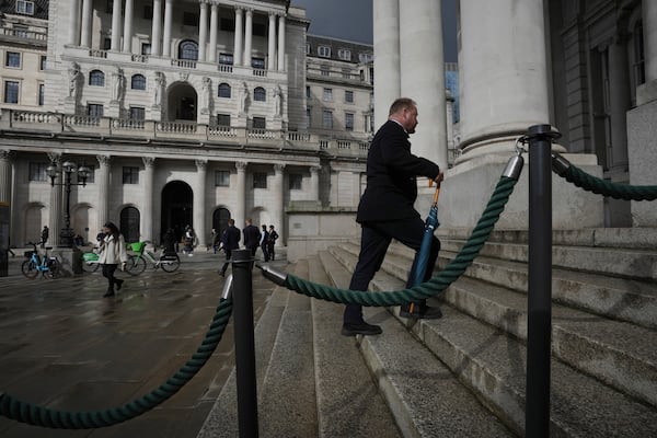 A man walks past Bank of England, at the financial district, in London, Thursday, March 13, 2025. (AP Photo/Kin Cheung)