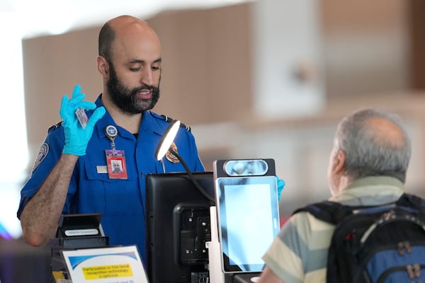 A TSA employee checks IDs as people move through security at Newark Liberty International Airport in Newark, N.J., Wednesday, May 7, 2025. (AP Photo/Seth Wenig)