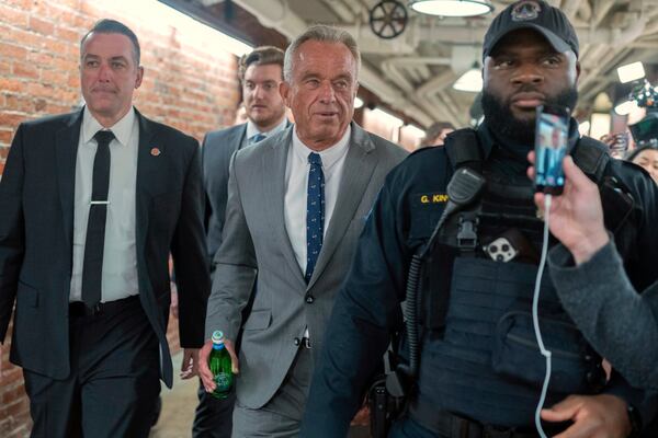 Robert F. Kennedy Jr., President-elect Donald Trump's nominee to be Secretary of Health and Human Services, center, walks to meet with Sen. John Thune, R-S.D. at the Capitol in Washington, Tuesday, Dec. 17, 2024. (AP Photo/Jose Luis Magana)